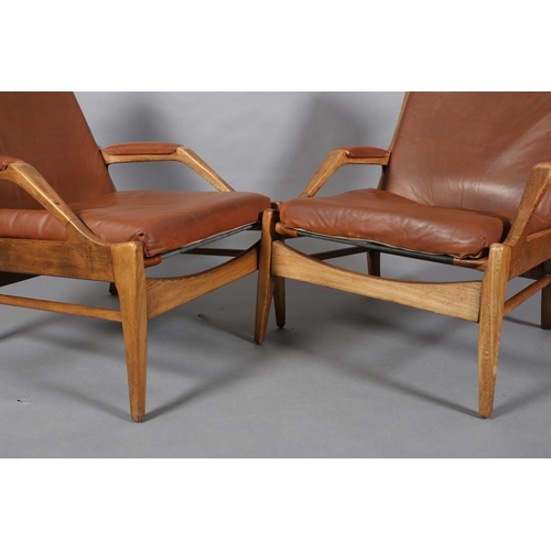 134 - A pair of polished beech and brown leather open armchairs on square tapered legs, c1970