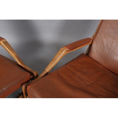 134 - A pair of polished beech and brown leather open armchairs on square tapered legs, c1970