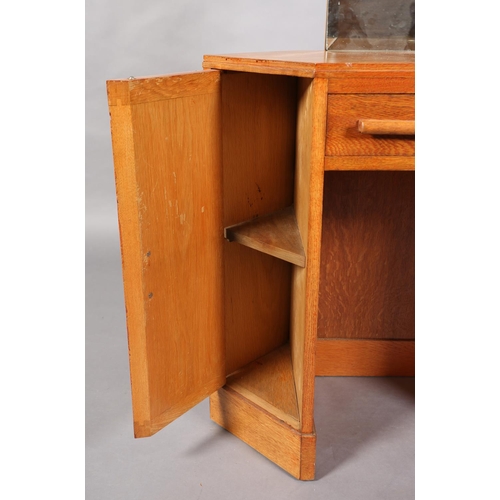 47 - A 1960s oak veneered dressing table, C.1960s of lozenge shape, having a bevelled mirror, two small d... 