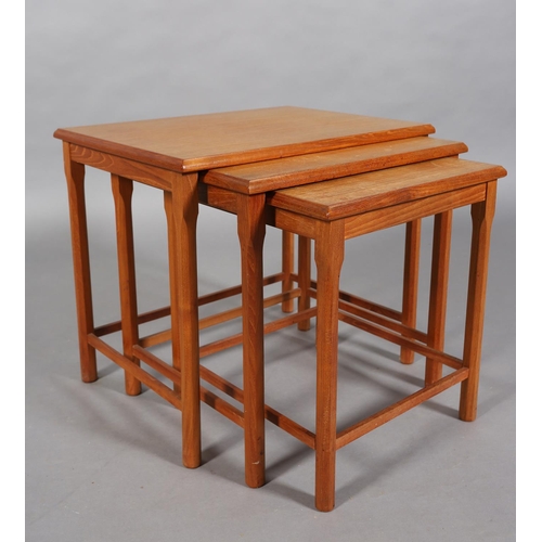 74 - A nest of three teak occasional tables, rectangular on chamfered legs, c1970s, 55cm wide x 47cm deep... 