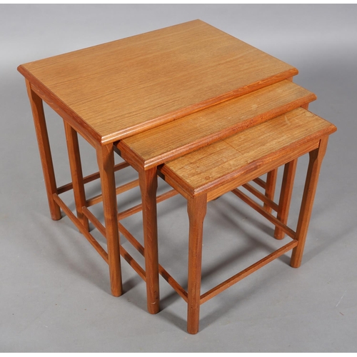 74 - A nest of three teak occasional tables, rectangular on chamfered legs, c1970s, 55cm wide x 47cm deep... 