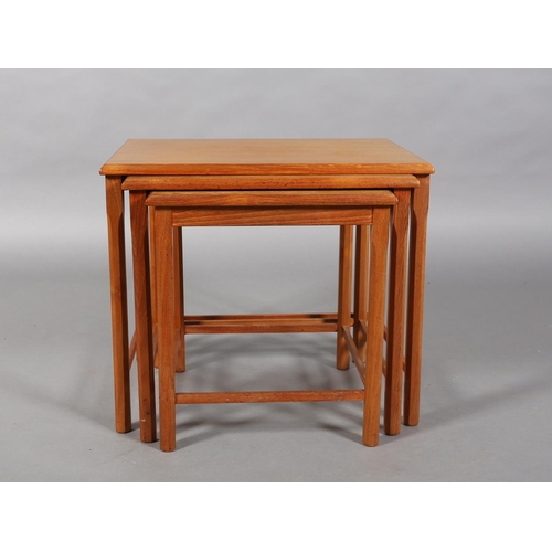 74 - A nest of three teak occasional tables, rectangular on chamfered legs, c1970s, 55cm wide x 47cm deep... 