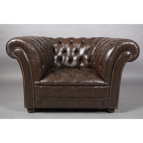 129 - A dark brown buttoned leather back Chesterfield club chair with close nail studding, on front bun fe... 