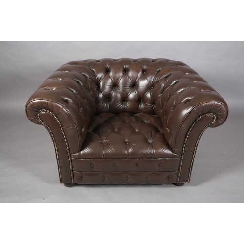 129 - A dark brown buttoned leather back Chesterfield club chair with close nail studding, on front bun fe... 