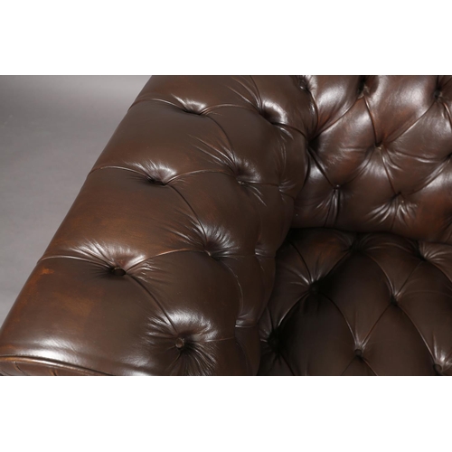 129 - A dark brown buttoned leather back Chesterfield club chair with close nail studding, on front bun fe... 