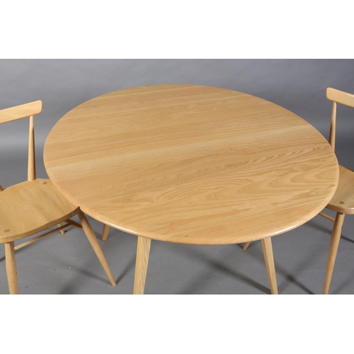 35 - A modern Ercol beech circular drop leaf dining table, on square tapered splayed legs together with a... 