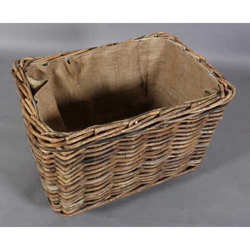 154 - A vintage wicker laundry basket, lined with sacking, on later wheels, 85cm wide x 57cm deep x 62cm h... 