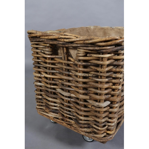 154 - A vintage wicker laundry basket, lined with sacking, on later wheels, 85cm wide x 57cm deep x 62cm h... 