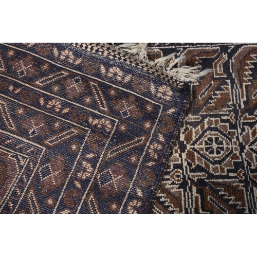 156 - A Caucasian rug, the camel ground with alternating panels of stylised plant forms in shades of brown... 