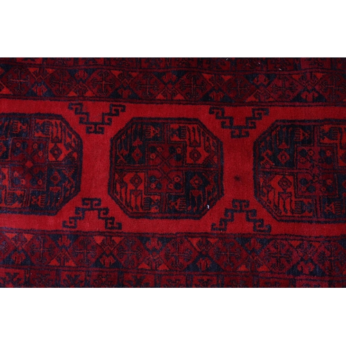 157 - A Bokhara rug, the scarlet field having three conjoined medallions filled with geometric design in w... 