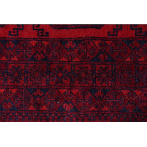 157 - A Bokhara rug, the scarlet field having three conjoined medallions filled with geometric design in w... 