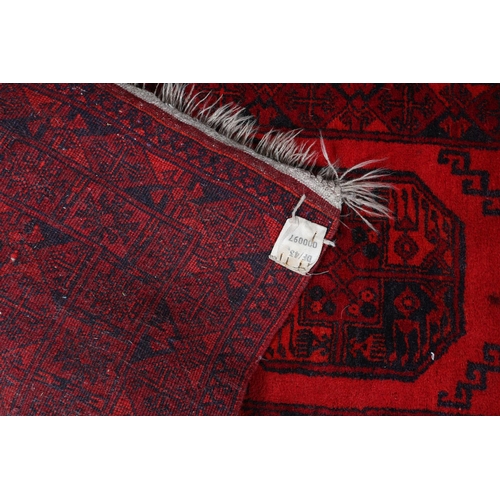 157 - A Bokhara rug, the scarlet field having three conjoined medallions filled with geometric design in w... 