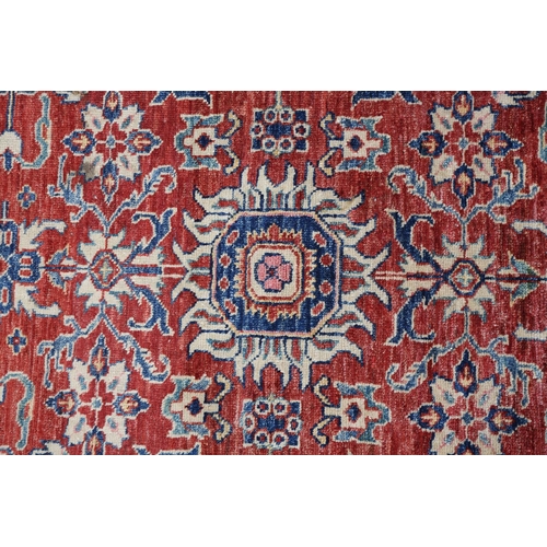 104 - A Caucasian rug, the fox red field filled with plant forms in ivory and blue, with conforming princi... 