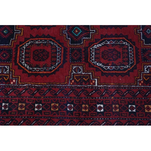 106 - A Bokhara rug, the wine field filled with two rows of four medallions in orange, white and black, pr... 