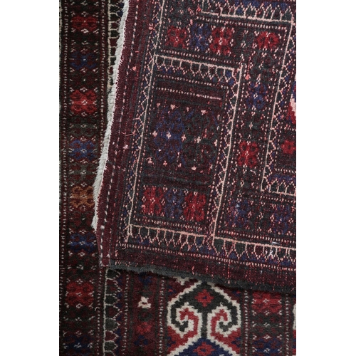 142 - A small Caucasian prayer rug, the prayer niche filled with three rows of blue, dark brown and off-wh... 