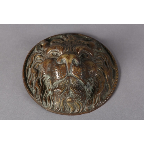 175 - A brass lion mask boss in high relief with a rope twist border to the rim, 17.5cm diameter