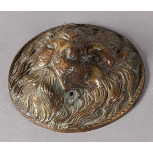 175 - A brass lion mask boss in high relief with a rope twist border to the rim, 17.5cm diameter