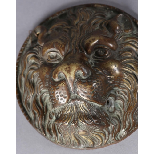 175 - A brass lion mask boss in high relief with a rope twist border to the rim, 17.5cm diameter