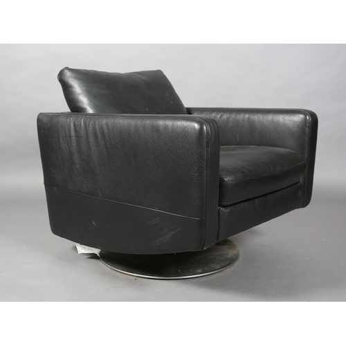 56 - A Natuzzi black leather swivel armchair of square form on a circular chrome base