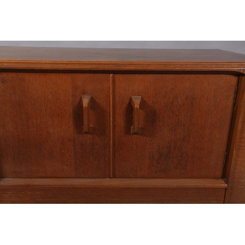 66 - An early G Plan Brandon oak sideboard, having a two door cupboard above a deep drawer flanked by a f... 