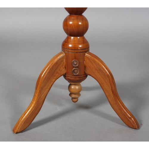 121 - A walnut tripod table, the circular top inlaid in exotic woods with a ring of circles of various siz... 