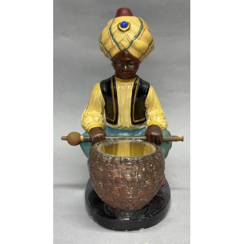 95 - A 1950s chalkwork figure table lamp model of a snake charmer, sitting cross-legged a basket with gla... 