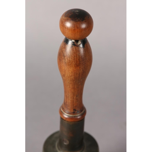 85 - An early 20th century handbell with turned wood handle, 26.5cm high together with a vintage cowboy's... 