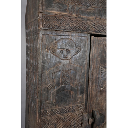 111 - An African inspired dark wood single door cupboard, having a wavy pediment carved with two crodiles ... 