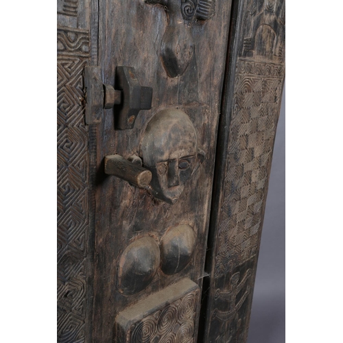 111 - An African inspired dark wood single door cupboard, having a wavy pediment carved with two crodiles ... 