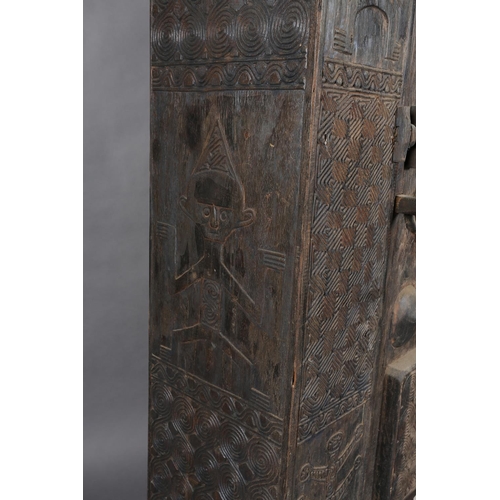 111 - An African inspired dark wood single door cupboard, having a wavy pediment carved with two crodiles ... 