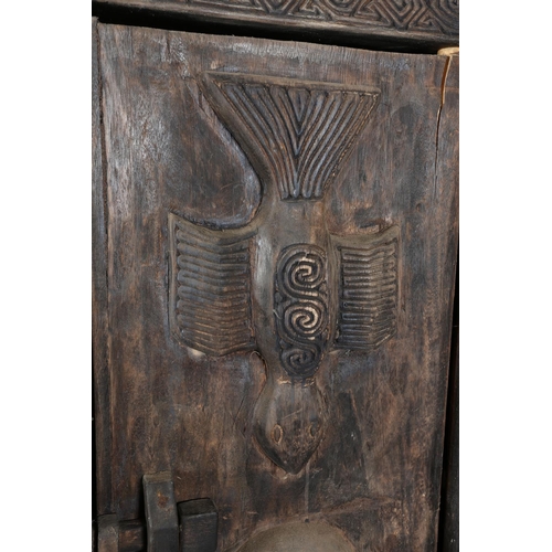 111 - An African inspired dark wood single door cupboard, having a wavy pediment carved with two crodiles ... 