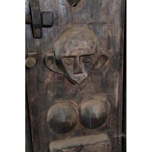 111 - An African inspired dark wood single door cupboard, having a wavy pediment carved with two crodiles ... 