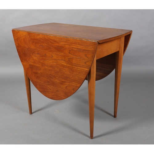 309 - A small teak oval drop leaf dining table, on octagonal and tapered legs, 145cm x 83.5cm