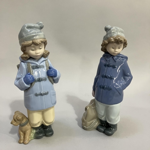 122 - Two Nao figures of children, one with hat ,coat and rucksack 19.5cm, one with hat, coat, rucksack an... 