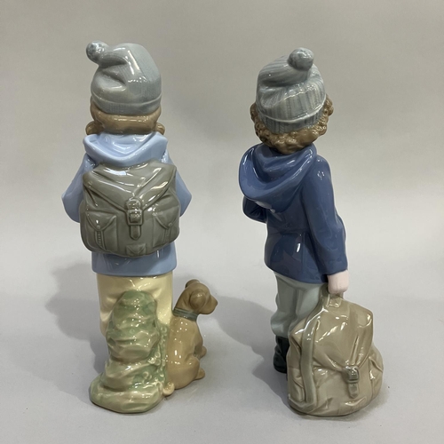 122 - Two Nao figures of children, one with hat ,coat and rucksack 19.5cm, one with hat, coat, rucksack an... 