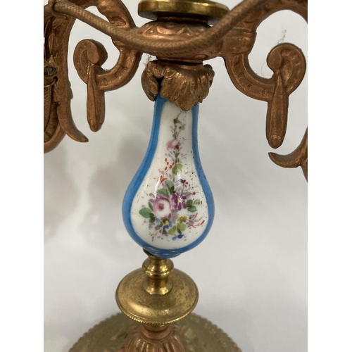 24 - A pair of gilt metal and porcelain candelabra with poly-chrome painted floral reserve to bluster col... 