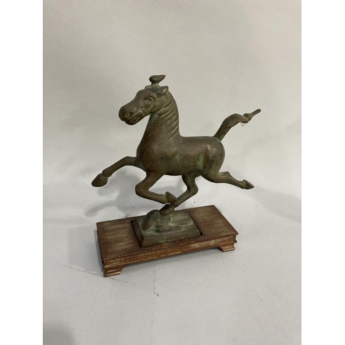 34 - A bronze effect model of the flying horse of Kang-Hsi on wooded stand together with another, approx.... 