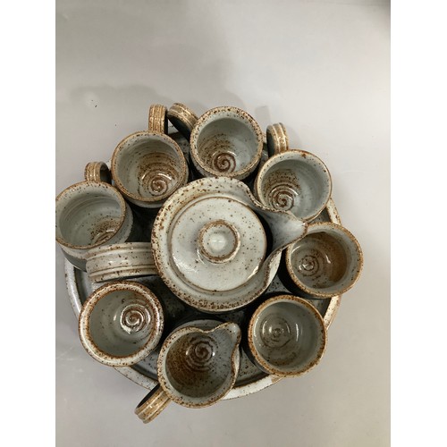 63 - A Studio Pottery coffee pot, sugar and cream, four mugs, two beakers and circular tray
