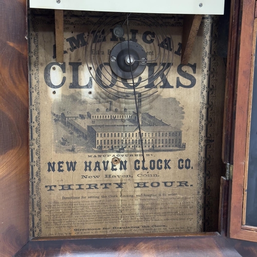 55 - A figured mahogany cased American clock by the Newhaven Clock Company, 30 hour movement, cream dial ... 