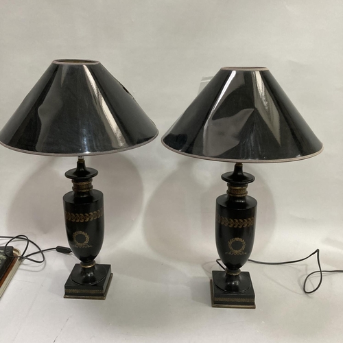 43 - A pair of black and gilt urn shape table lamps on square bases, with shades