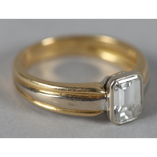 439 - A SINGLE STONE DIAMOND RING in 18ct yellow and white gold, the emerald cut stone collet set flanked ... 