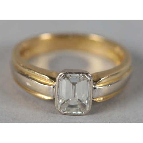 439 - A SINGLE STONE DIAMOND RING in 18ct yellow and white gold, the emerald cut stone collet set flanked ... 