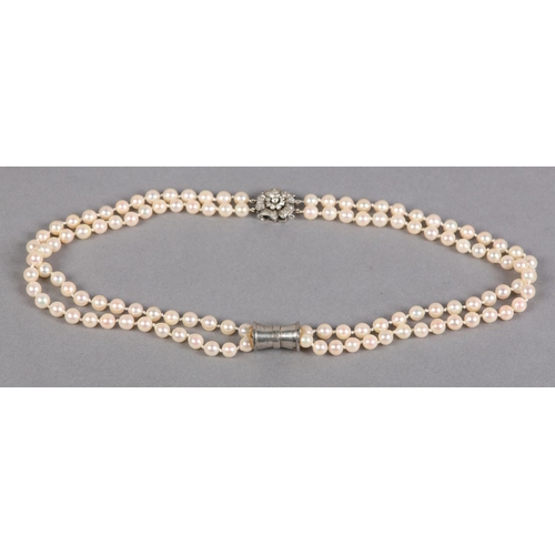 432 - A CULTURED PEARL AND DIAMOND NECKLACES, c1950, the two rows of 7mm pearls fastened with a four row s... 