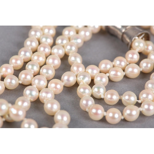 432 - A CULTURED PEARL AND DIAMOND NECKLACES, c1950, the two rows of 7mm pearls fastened with a four row s... 