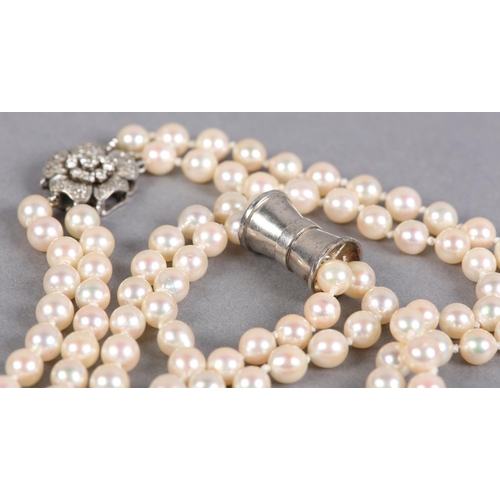 432 - A CULTURED PEARL AND DIAMOND NECKLACES, c1950, the two rows of 7mm pearls fastened with a four row s... 