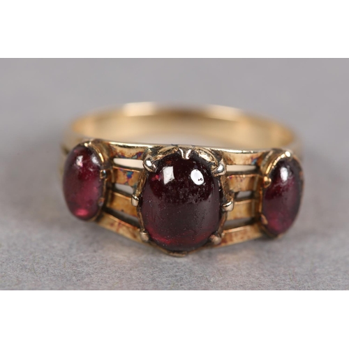 427 - A LATE VICTORIAN THREE STONE CABOCHON GARNET RING in 9ct rose gold, the oval graduated stones, claw ... 