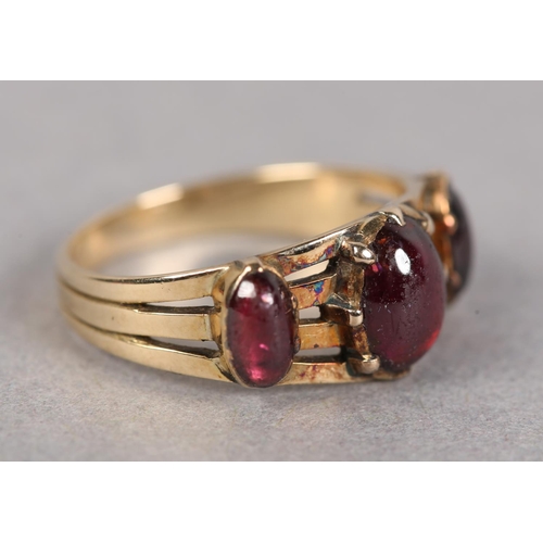 427 - A LATE VICTORIAN THREE STONE CABOCHON GARNET RING in 9ct rose gold, the oval graduated stones, claw ... 