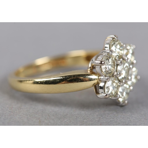 435 - A DIAMOND CLUSTER RING in 18ct yellow and white gold, the brilliant cut stones claw set within a cir... 