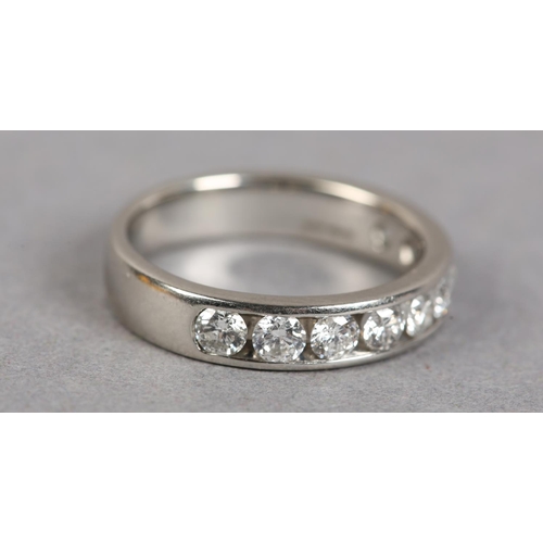 438 - A HALF HOOP DIAMOND RING IN PLATINUM, the brilliant cut stones channel set in line, finger size N 1/... 