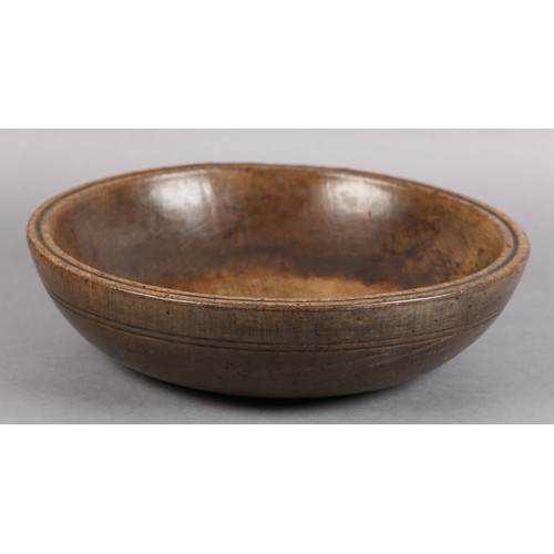 75 - A 19TH CENTURY TURNED FRUIT WOOD DAIRY BOWL, with moulded rim and simple incised line decoration, 35... 